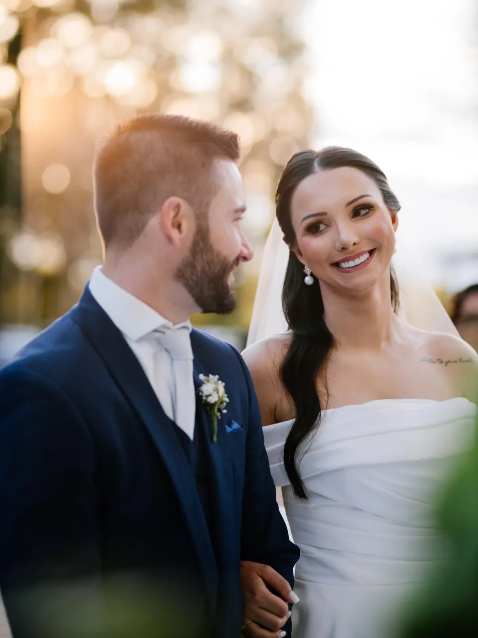 Noivos sorrindo de braços dados no dia do casamento
